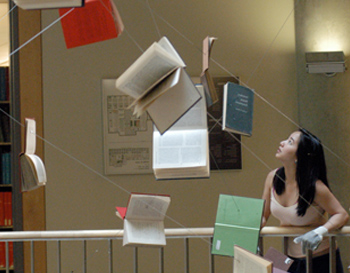 Student looking at books that have been strung up in the air