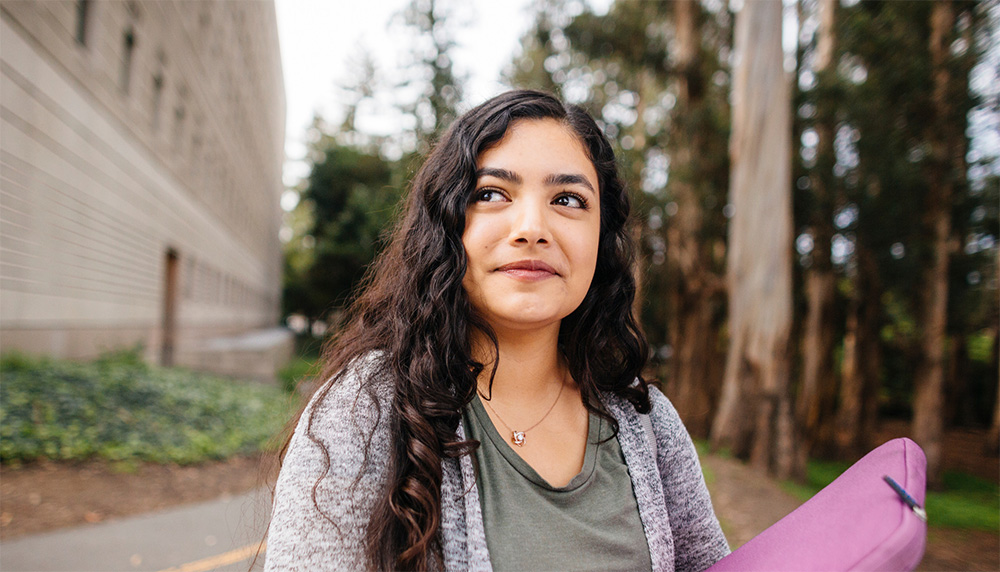 Student on the UC Berkeley campus holding a laptop case